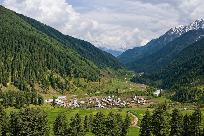 Aru village surrounded by forested mountain slopes