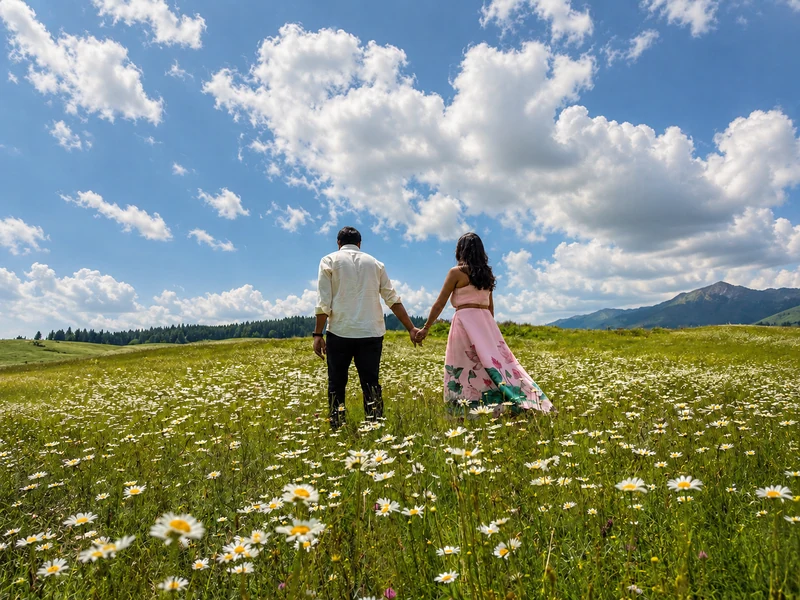Couple walking through a flowering Kashmir meadow