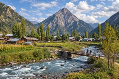 Wooden village houses and a footbridge beside a Gurez river