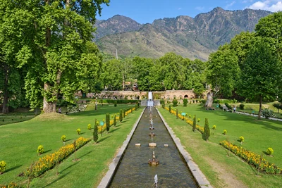 Nishat Bagh lawns and water channel below the mountains