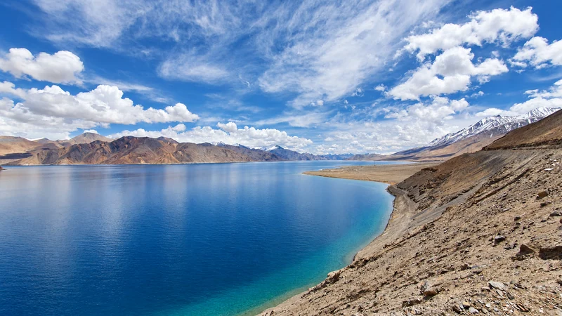 Pangong Lake beneath mountain ridges and passing clouds