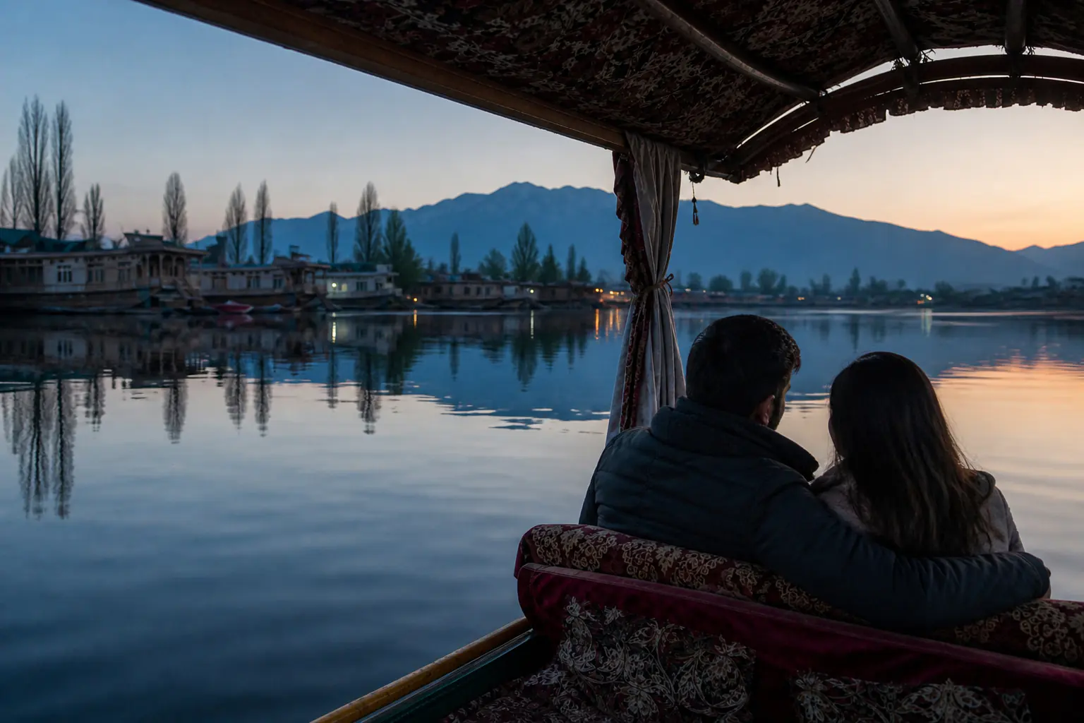 A naturally posed couple crossing Dal Lake by shikara at dusk